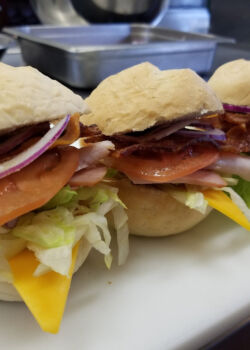 Club sliders with ham, turkey, bacon, cheddar, tomato, red onion, lettuce and mayonnaise
